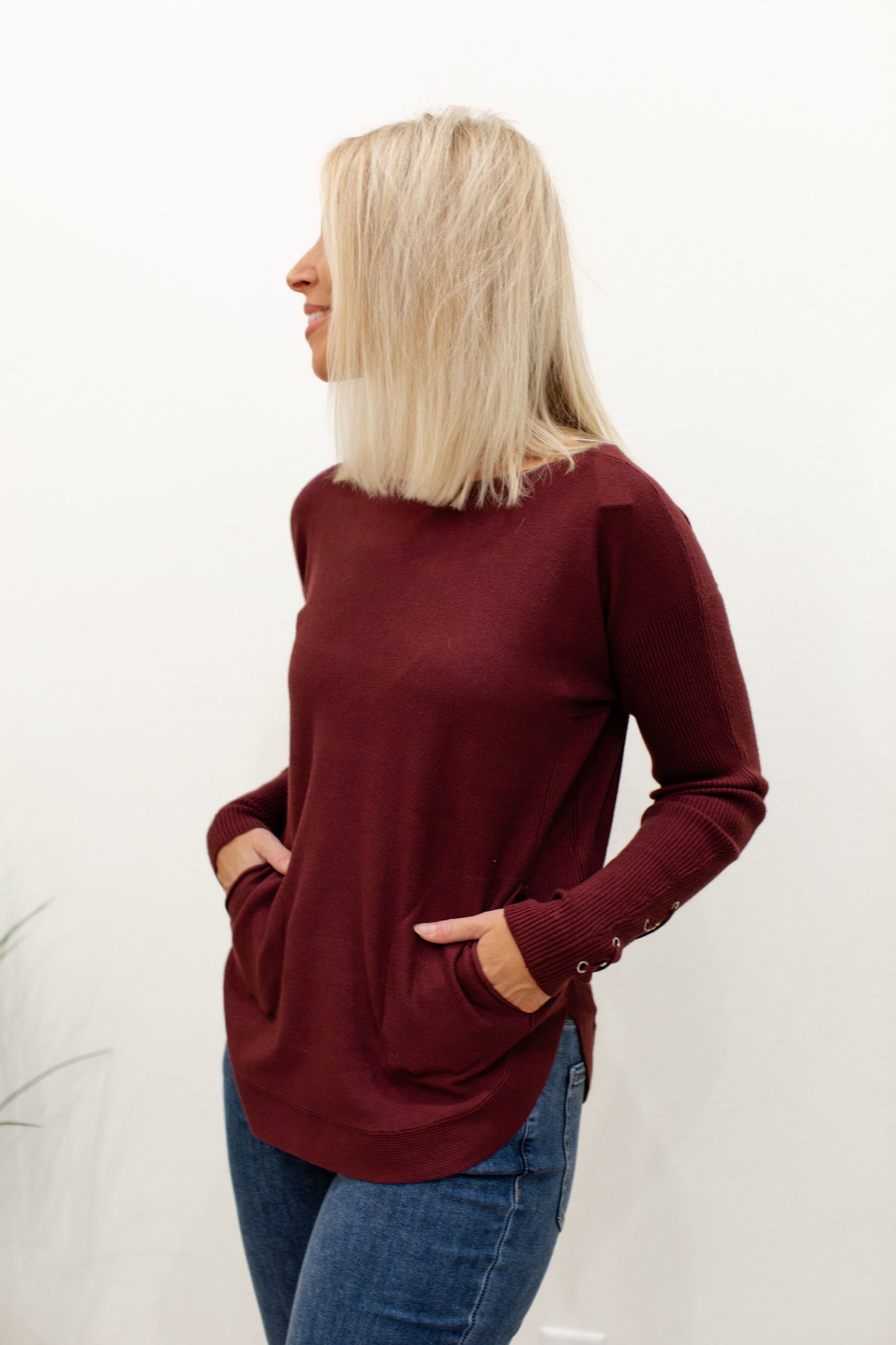 Cabernet Round Hem Sweater With Front Pockets And Sleeve Lacing Details