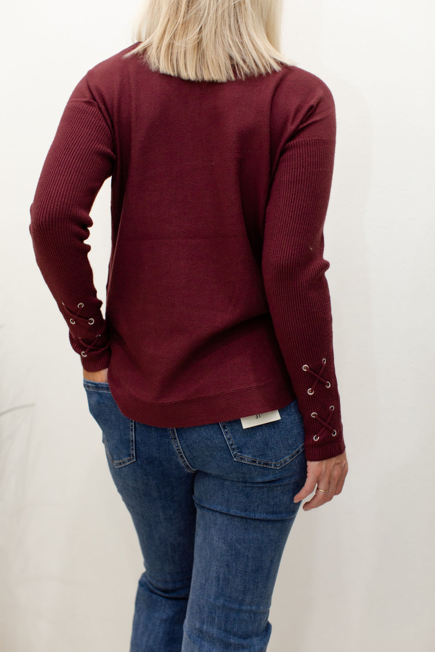 Cabernet Round Hem Sweater With Front Pockets And Sleeve Lacing Details