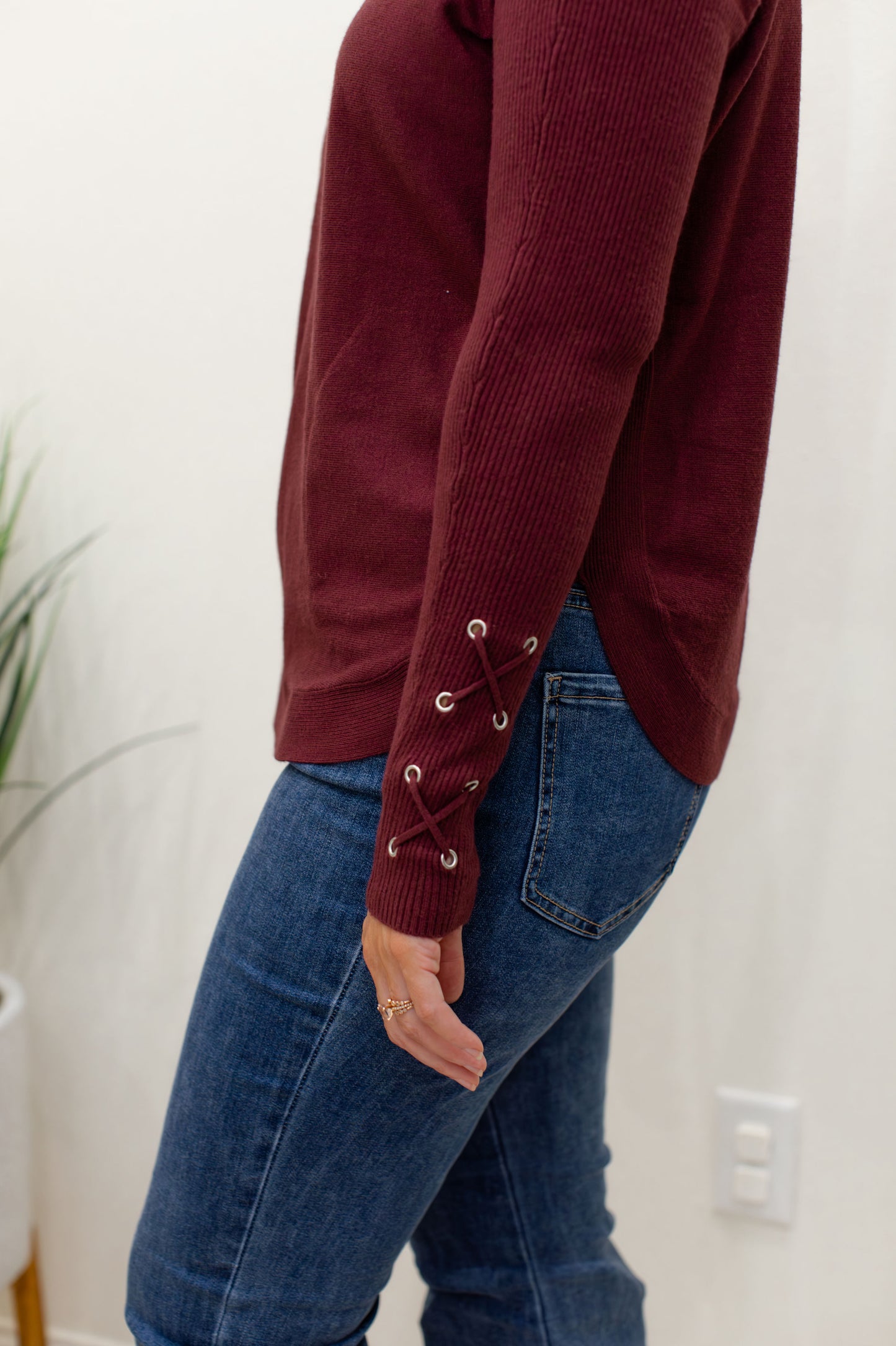 Cabernet Round Hem Sweater With Front Pockets And Sleeve Lacing Details